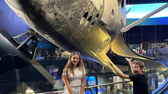 Ezra and his sister in front of a rocket