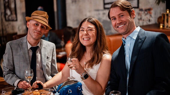 Trio of attendees enjoying wine together.