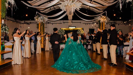 Emely in her green ballgown with her court entering the dance floor