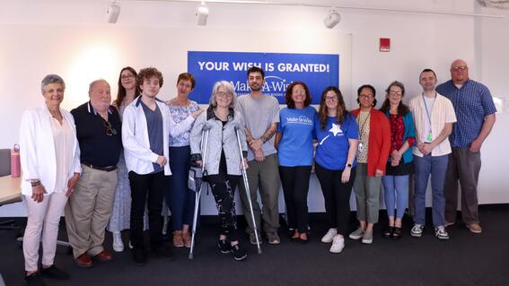 Nate poses with MassArt President Dr. Mary K. Grant and other members of MassArt leadership as well as family, friends, and Make-A-Wish representatives at his wish celebration