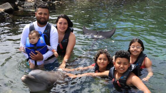 Deydalie and her family swimming with dolphins during her wish trip.