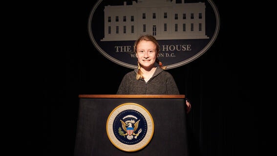 Abbie Tremp standing in front of a podium at the White House.