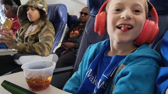 Sammy on the plane smiling sticking his tongue out playfully