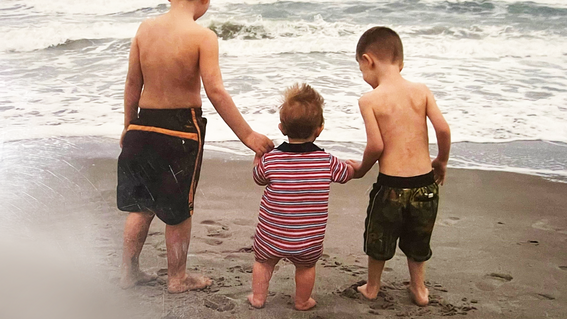 Ethan Hite standing by the ocean with brothers