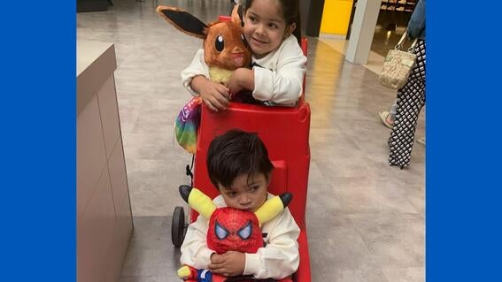 Leonel holding a stuffed Pikachu dressed in a Spider-Man costume, with his sister Miranda at the mall in 2022.