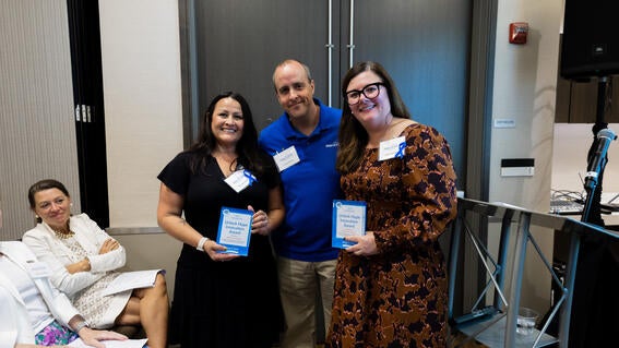 Senior Volunteer Manager Daniel Marlay presents Monica Carrillo (left) and Kelsey Karrigan (right) with the Unlock Hope Innovation Award at the Wish Insiders Monterey for their incredible enhancement on Zuriah’s wish to have a big cat experience.