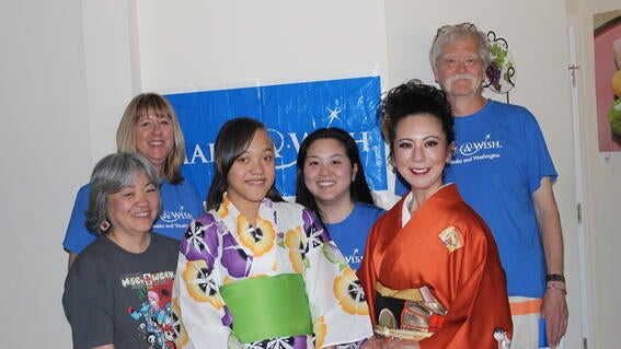 Katina standing in a group with her volunteers, smiling at the camera 