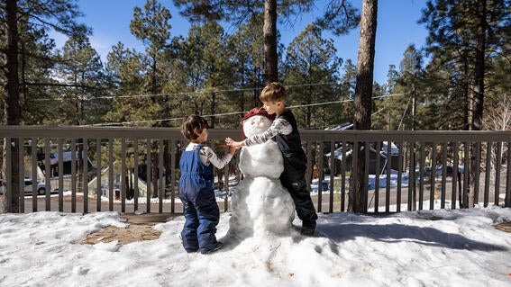 Nash builds a snowman with his brother.