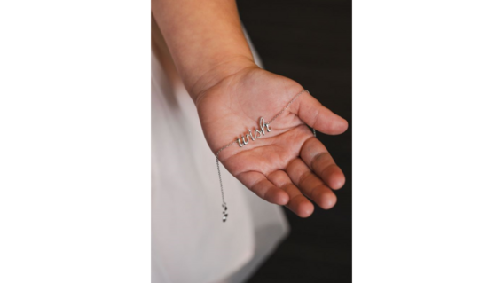 Wish child with "Wish" bracelet in her hand