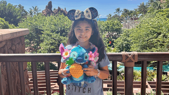Sophia holding a Stitch stuffed animal at the resort