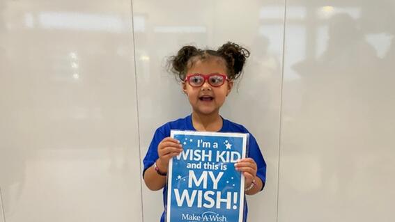 wish kid hazel holding a sign that says "I am a wish kid and this is my wish!"
