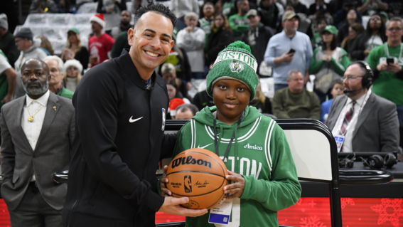 Ikenna presents the game ball for the Christmas day Boston Celtics game at TD Garden