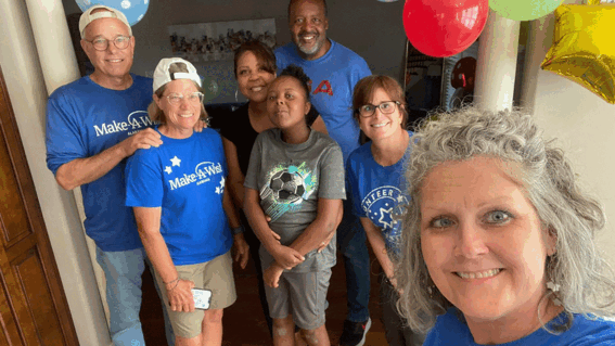 A group of volunteers surround a child on their wish day.