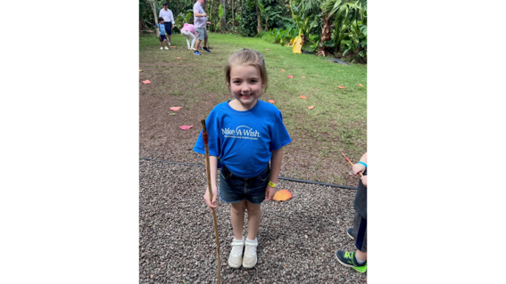 Wish kid Aileen poses in her blue Make-A-Wish t-shirt outside in Hawaii