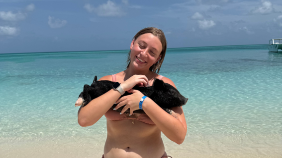Briana holding a pig on her wish trip to The Bahamas to swim with pigs