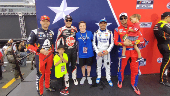 Caleb posing for a photo with NASCAR drivers