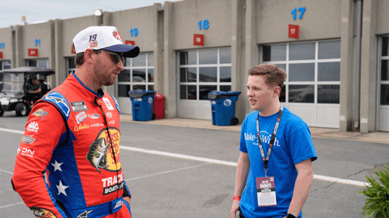 Caleb standing with a racecar driver