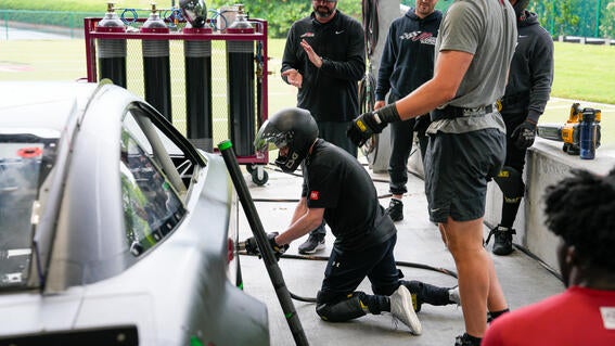 Caleb working with mechanics on a racecar