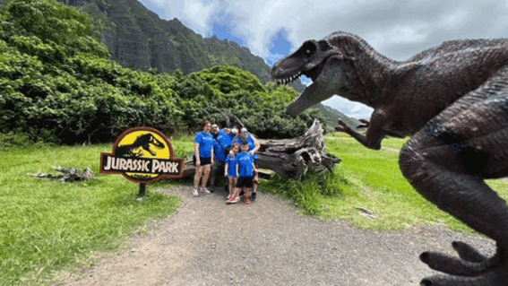 Family standing behind a statue of a dinosaur