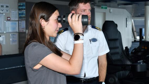 Rachael with cruise captain looking through binoculars 