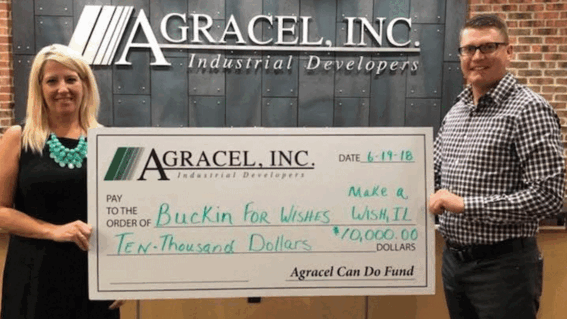 Beth holding a check donation for Make-A-Wish