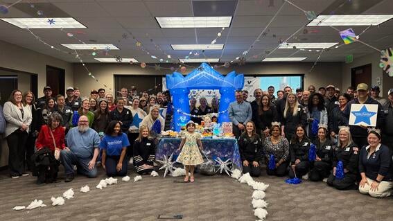 A little girl with a group of employees