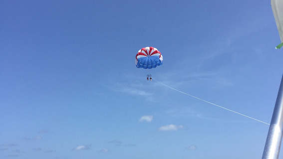 Isabella soars high above the bright blue Bahamian waters while parasailing. 