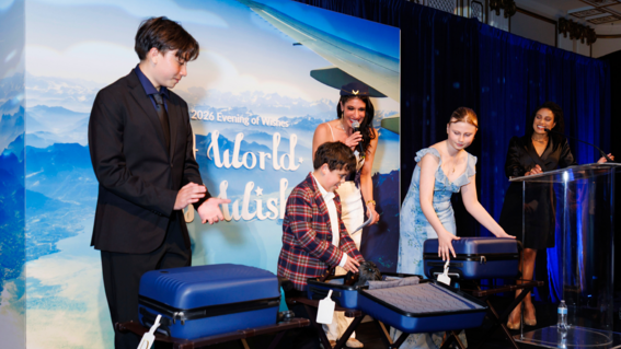 Wish kids receiving gifts on stage at Evening of Wishes: A World of Wishes