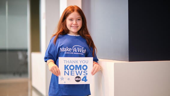 Wish Kid Olivia holding KOMO Sign