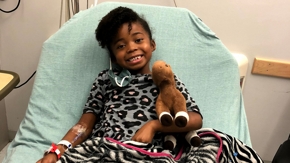 Suriha in the hospital, stuffed horse by her side. 