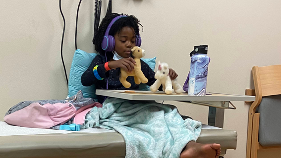 Suriha playing with toy horses during a hospital visit. 