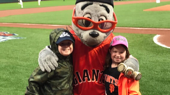 wish kid Ben and his younger sister Morgan with Lou Seal on the field