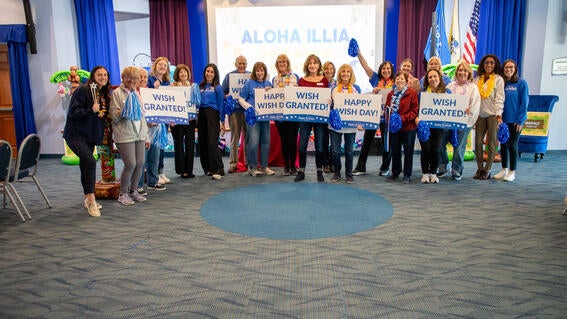 Image shows a group of volunteers posing with signs