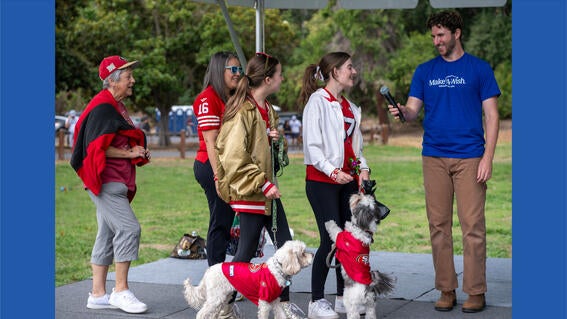 Dogs and humans in 49ers gear cross the stage