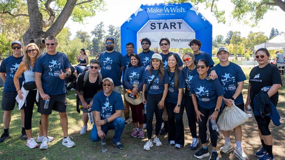 Team Corsair, a large group, poses in front of the Finish arch