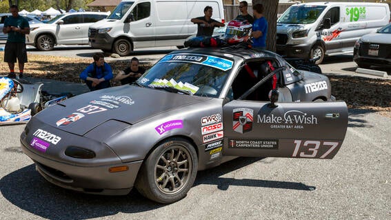 Silver race care with Make-A-Wish logo on door