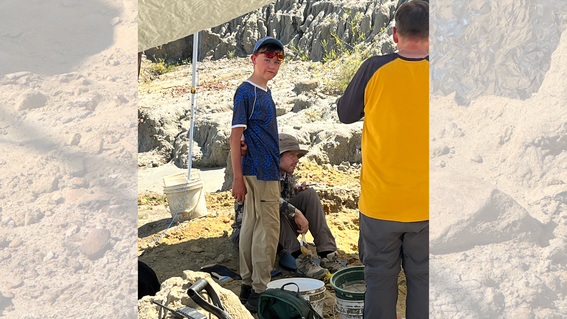 Ian at the dig site with tools around him
