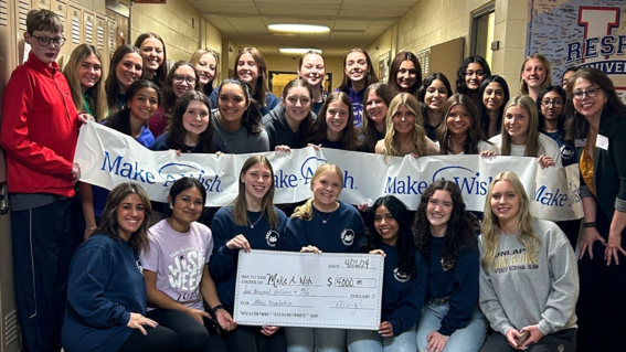 Students from Dunlap High School present a donation check
