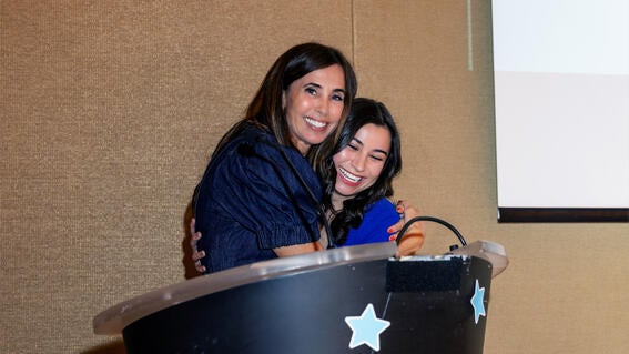 Marketing Operations Manager Tracie Muñoz congratulates Storyteller’s Award recipient Milan Alas.