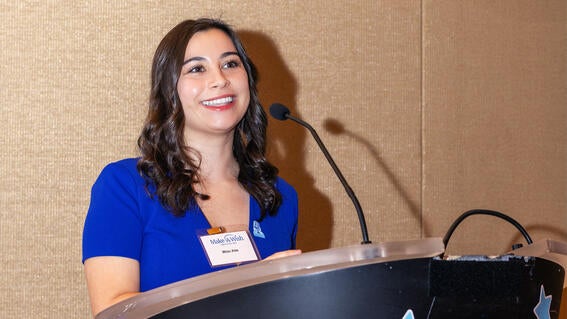 Milan Alas accepts the Storyteller’s Award on behalf of herself and fellow recipient Matthew Ilg, her co-host on The Wish Kids podcast.