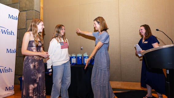 Events Development Manager Kendra Uffelman and Senior Events Manager Rachel Faught present sisters GG and Lauren Gallagher with the Youth Leadership Award. 