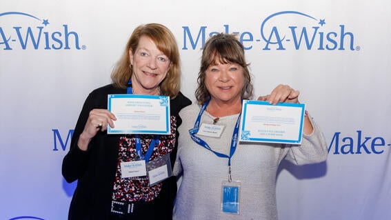 Volunteers Helen Flynn and Lisa Fabiani Wyatt accepting their Wish Impact Pin for Airport Volunteers