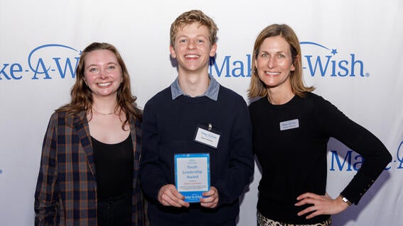 Make-A-Wish staff members Rachel Faught on the left, and Kendra Uffelman on the right, with Youth Leadership award winner, Dylan Lachance, in the center