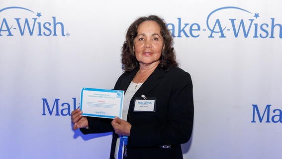Volunteer Olga Borjon accepting their Wish Impact pin for Shopping Spree volunteers