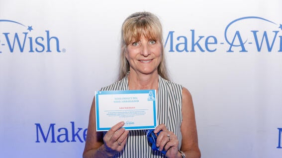 Volunteer Juliet Vadvilavich accepting their Wish Impact Pin for Wish Ambassadors