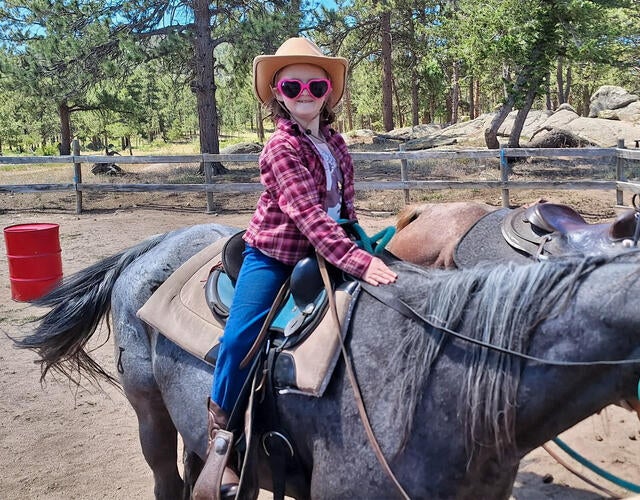 Wish kid Mary Alice riding a horse wearing a cowboy hat and sunglasses