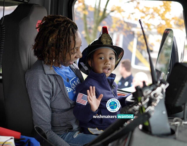 Michigan wish kid Jayce sitting on his mom's lap in a fire truck