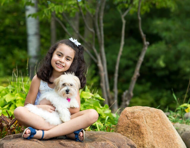 Wish kid Jade holding her new puppy