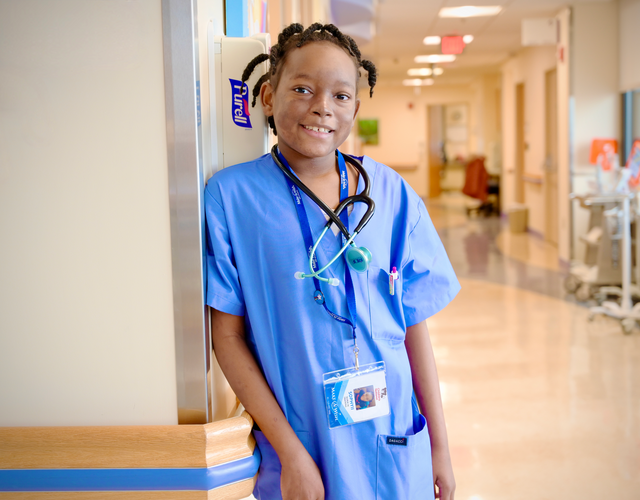 Wish kid Sophyii in a nurse uniform in a hospital hallway