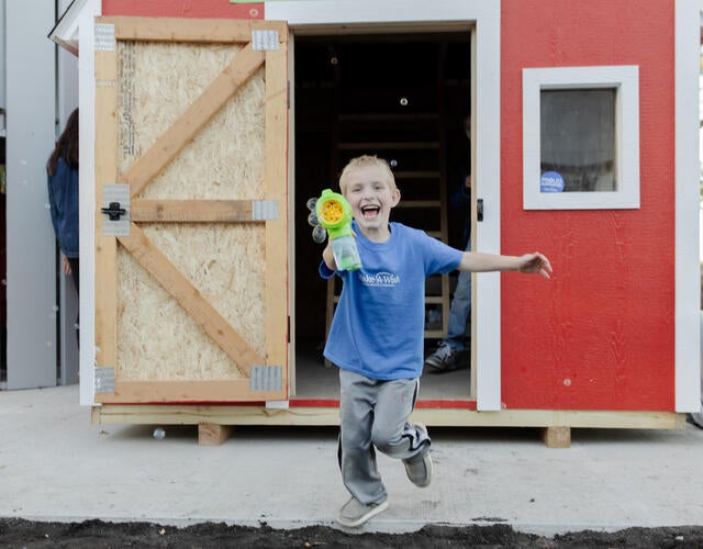 Wish kid David in front of his new playhouse